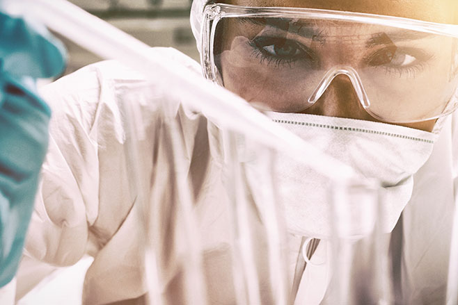 Close up of a protected science student dropping liquid in a