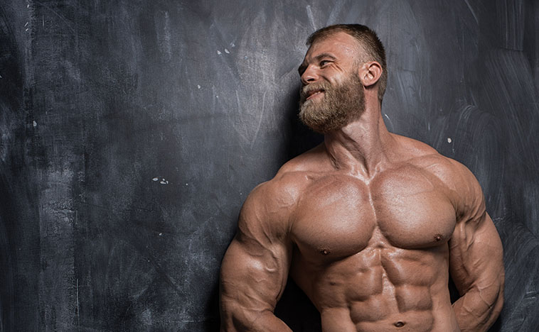 Handsome muscular man bodybuilder posing in the studio on a darck background