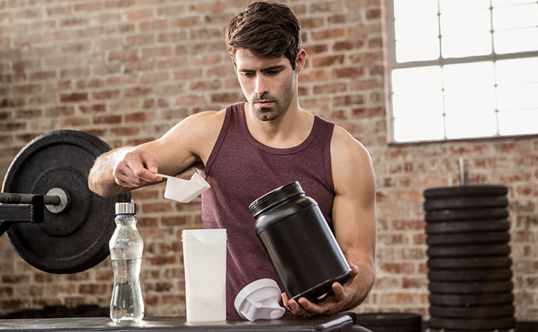 Man adding supplement from tin to bottle